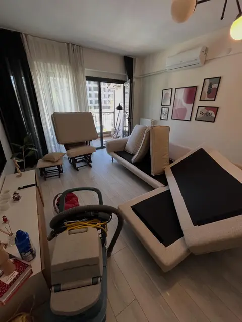 Krem kanepe ve sallanan koltuk, minderler kurumaya bırakılmış — İzmir